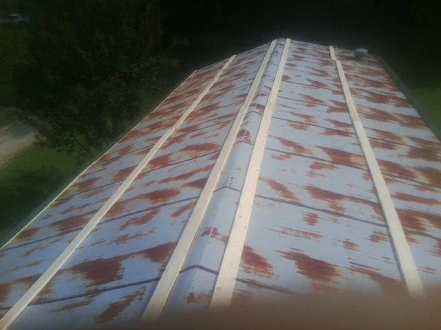 Rusted metal roof panels with new wood purlins before replacement — Storm Damage Roof Repair in Walla Walla by Roofing Brothers