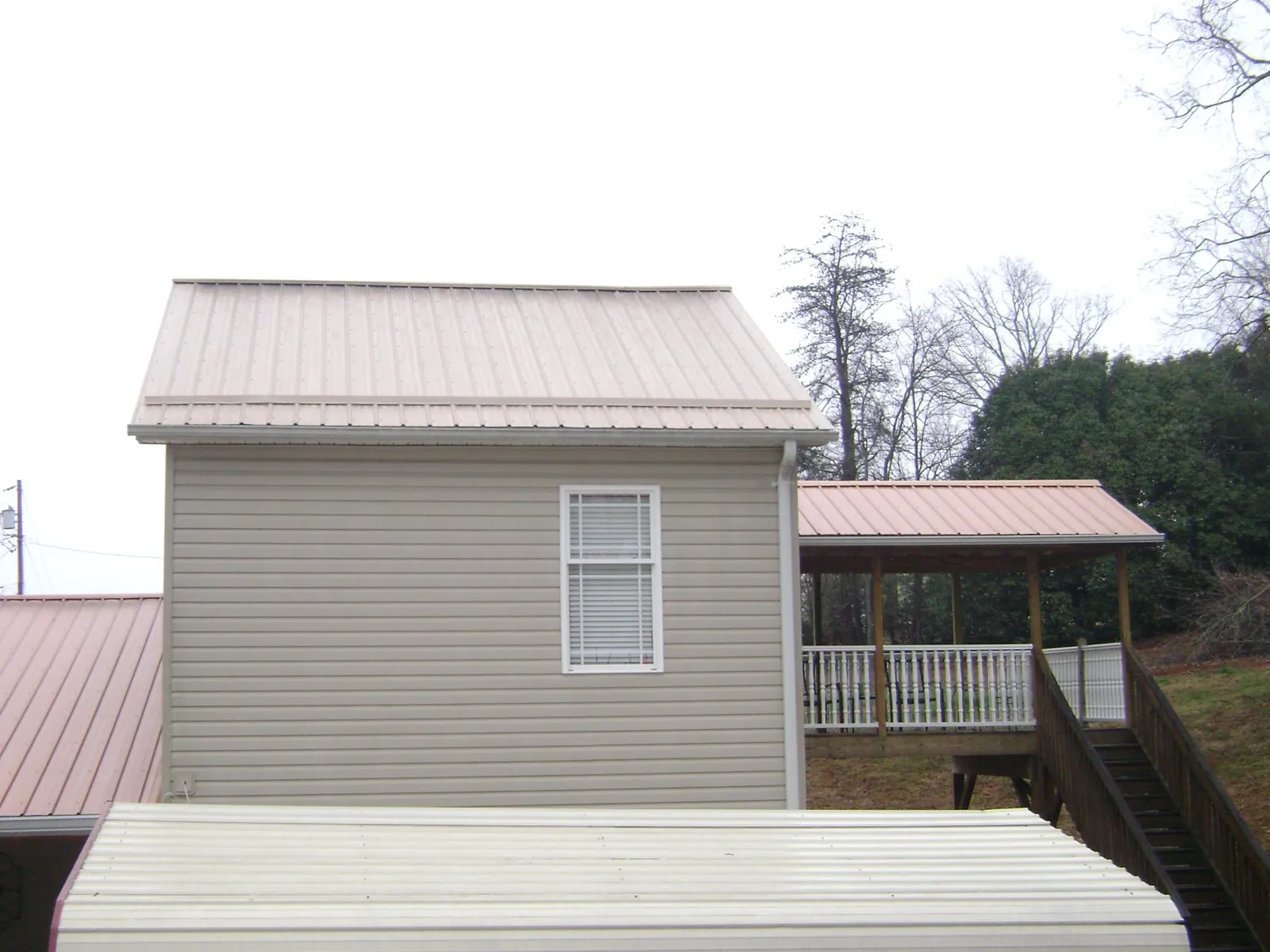 Tan metal roofs on a two story addition and attached porch, from a Roof Replacement job in Walla Walla